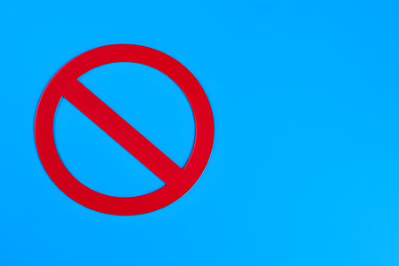Red prohibition sign on blue background, 3d rendering. Computer digital drawing.の素材