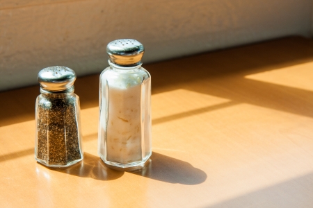 salt and pepper shakers on wooden tableの写真素材