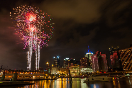 Pittsburgh, PA river view skyline at night with colorful firework 
