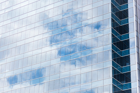 Modern building glass windows with sky reflection.
