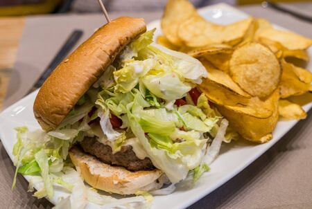 Juicy BLT burger with potato chips.の写真素材