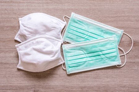 Cloth and surgical face masks for preventing covid 19 disease on wooden backgroundの写真素材