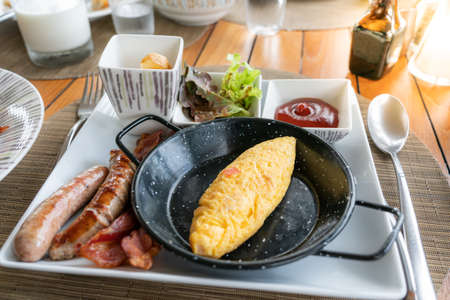 Classic western breakfast plate with omelette, sausages and bacons