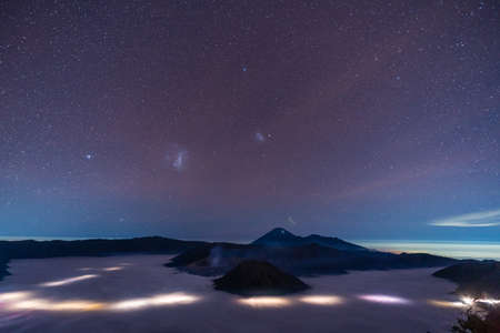 Mount Bromo volcano with million stars at night in East Java, Indonesia surround by morning fogの写真素材