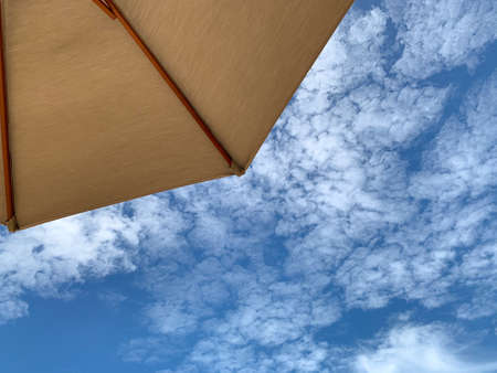 Beach umbrella against bright blue summer skyの写真素材