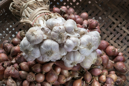 garlic and red onion on wooden basketの写真素材