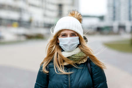 The woman wears a protective mask from allergies, viruses, air pollution. Concept climate change.