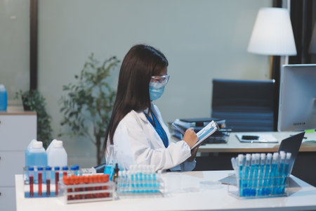 Group of dedicated scientist conduct chemical experiment in medical laboratory, carefully drop precise amount of liquid from pipette into test tube for vaccine drug or antibiotic development. Neotericの写真素材