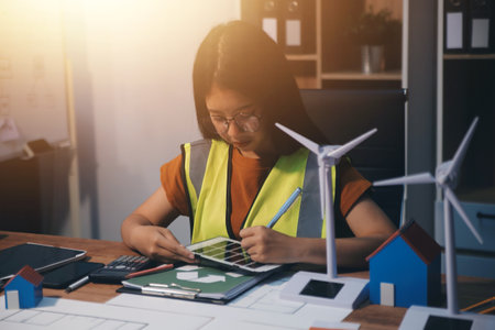 Female architect working at home. She looked at the blueprint.の写真素材
