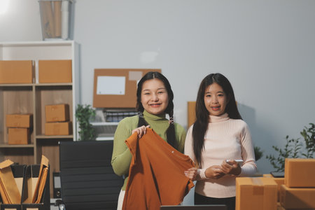 Startup SME small business entrepreneur of freelance Asian woman wearing apron using laptop and box...