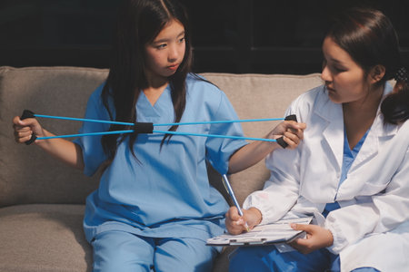 Doctor physiotherapist assisting a patient while giving exercising treatment on stretching her arm...