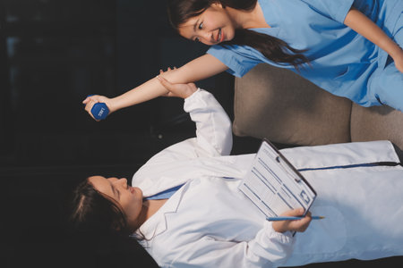 Unrecognizable uses blue hand weight during physical therapy sessionの写真素材