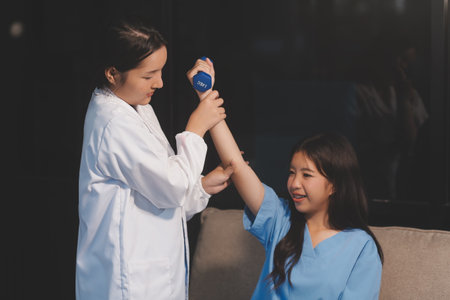 Unrecognizable uses blue hand weight during physical therapy sessionの写真素材