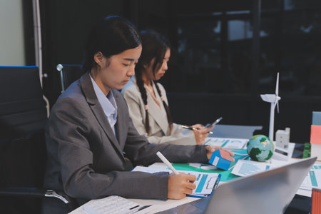Asian woman lead young group of multiethnic businesspeople in team meeting, using laptop computer...