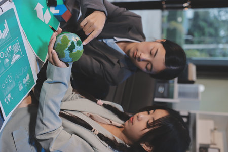 Asian woman lead young group of multiethnic businesspeople in team meeting, using laptop computer for ESG topic presentation on monitor. Sustainable business practice, people work at home conceptの写真素材