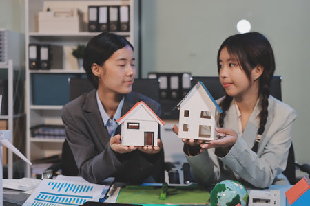 Asian woman lead young group of multiethnic businesspeople in team meeting, using laptop computer for ESG topic presentation on monitor. Sustainable business practice, people work at home conceptの写真素材