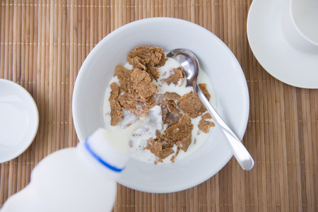 adding milk on cornflakeの写真素材