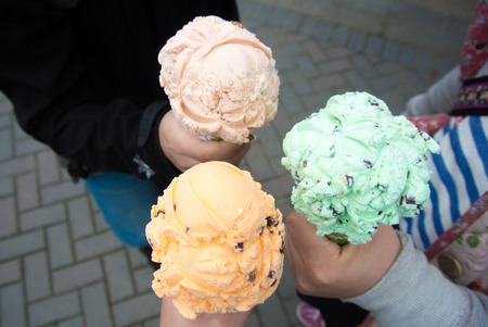 Three guys holding ice creems on their hands