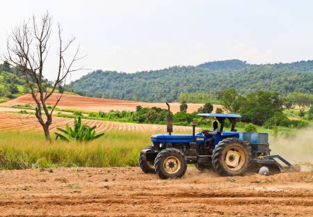 The blue tractor working on a fieldの写真素材
