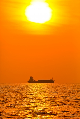 Silhouette of cargo ship with sunsetの写真素材