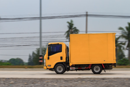 Yellow truck moving at high speed with blurred backgroundの写真素材