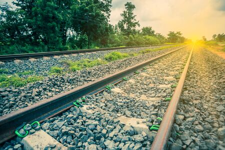 Railway tracks in a rural scene with sunbeam