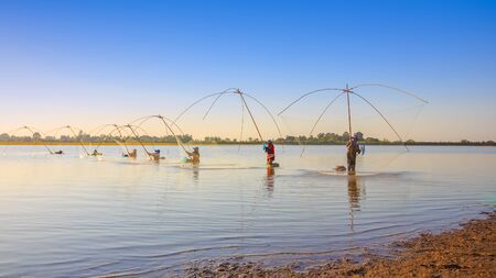 Group of women are catching fish by traditional equipment in the lakeの写真素材