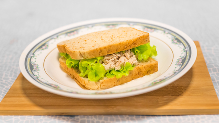 sandwich chicken breast in white dish on wooden tableの写真素材