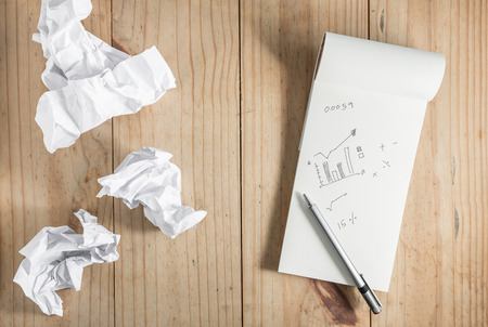 white paper and crumpled paper and gray pencil on wooden backgroundの写真素材