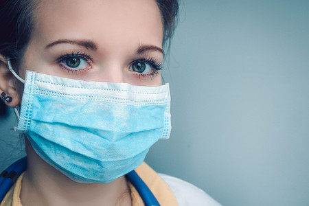 Close up portrait of female doctor or nurse wearing protective mask