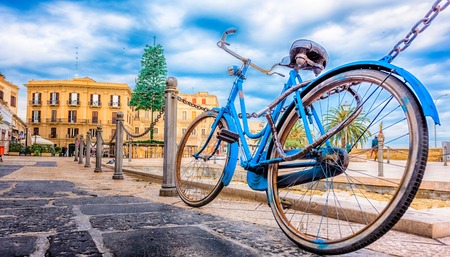 Old blue bicycle with the old town in the background, Bari, Puglia, South Italyの写真素材
