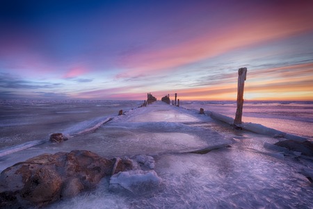 Winter seascape of wood breakwaters on frozen Baltic seaの写真素材