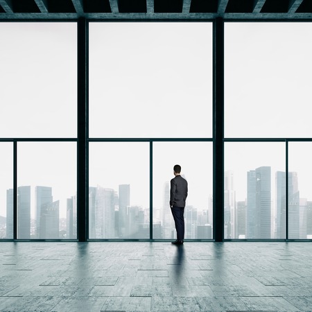 Businessman in suit looking at sunrise in the cityの写真素材