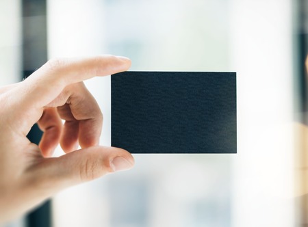 Hand holding business card on blurred backgroundの写真素材