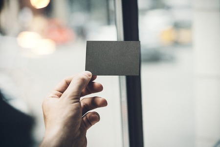 Hand holding business card on blurred backgroundの写真素材