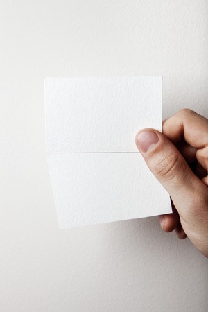 Hand holding business card on wall backgroundの写真素材