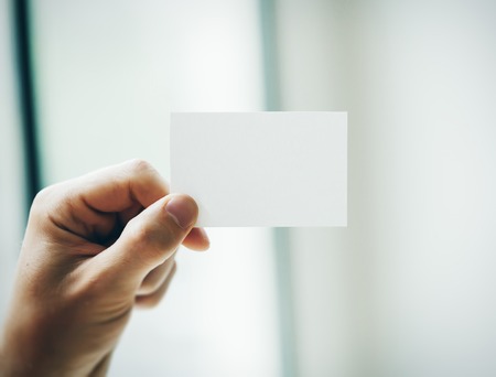 Hand holding business card on blurred backgroundの写真素材