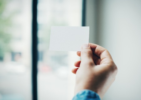 Hand holding business card on blurred backgroundの写真素材