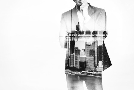 Double exposure concept with thinking business man and city on the backgroundの写真素材