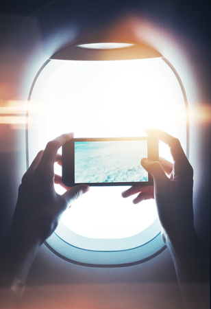 Mock up of smart phone in female hand, with visual effects, private jet.の写真素材