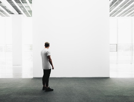 A man walks on the exhibition hall and examines the gallery of the exhibitionの写真素材