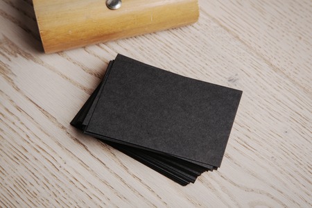Black business card of kraft paper. Set of blank office elements on the wooden backgroundの写真素材
