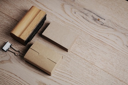 Blank business cards of the kraft paper. Set of blank office elements on the wooden background