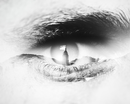 Bw close-up of human eye with visual effects and double exposure  skyscrapers and the mountains on the backgroundの写真素材