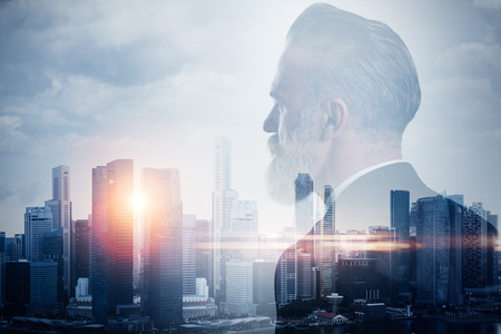 Stylish businessman in a suit looking at the horizon. Photo of double exposure of the cityの写真素材