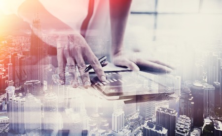 Photo female hand touching modern tablet.Investment manager working new private banking project office.Using electronic device. Graphic icons,worldwide stock exchanges interface on screen.  Horizontalの写真素材