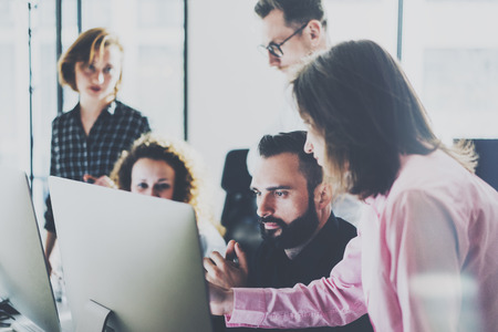 Coworker photo in modern office.Project managers team work new idea.Young business crew working with startup modern studio.Desktop computer on table,showing presentation.Blurred,film effect.Horizontalの写真素材