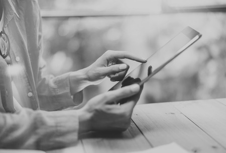 Work process modern Loft.Hipster working wood table with new freelance business startup.Marketing Department Research Process.Touching Screen Digital Tablet.Horizontal.Black White.Blurred backgroundの写真素材