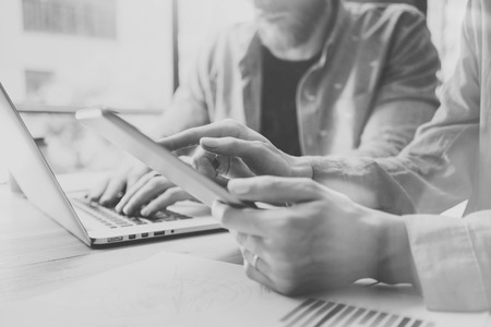 Work Process in Modern Design Studio. Account Managers Working at Wood Table with New Business Project.Touching Screen Digital Tablet.Man using Laptop.Horizontal. Black White. Blurred backgroundの写真素材