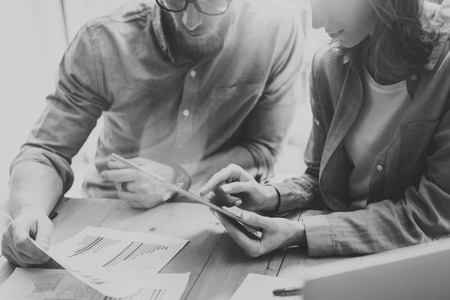 Photo Sales Manager Working Modern Studio.Woman Showing Market Reports Digital Tablet.Account Department Work New Startup Project.Researching Process Wood Table.Blurred Background.Black Whiteの写真素材